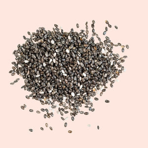 Pile of chia seeds on a pink background
