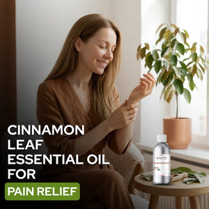 Woman applying cinnamon leaf essential oil to her hand with a bottle of the product on a small table.