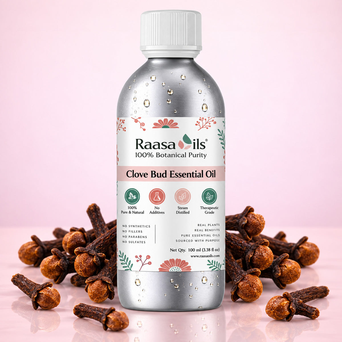 A bottle of Raasails Clove Bud Essential Oil centered on a soft pink background, surrounded by scattered cloves. The bottle is metallic silver with a white cap and a white label featuring green and coral floral details.