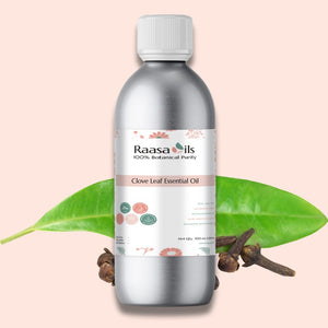 Raasa Oils clove leaf essential oil bottle with leaves and cloves on a pink background