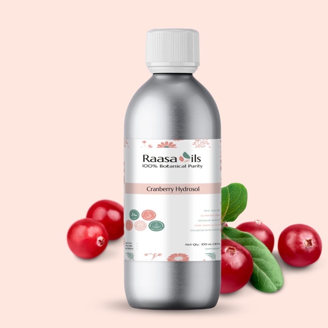Bottle of Raasa Oils Cranberry Hydrosol with cranberries and leaves on a light pink background