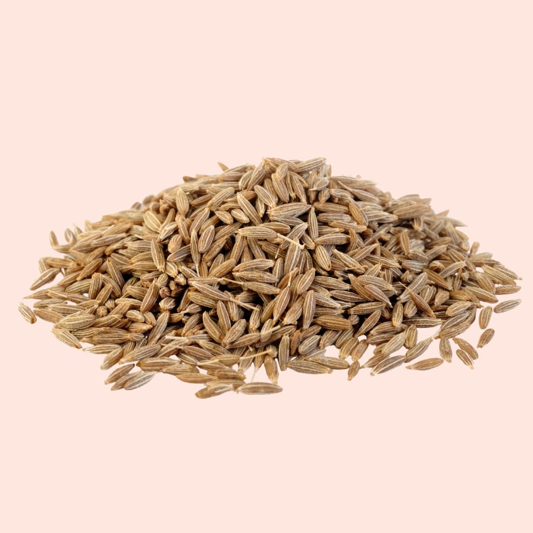 Pile of cumin seeds on a beige background
