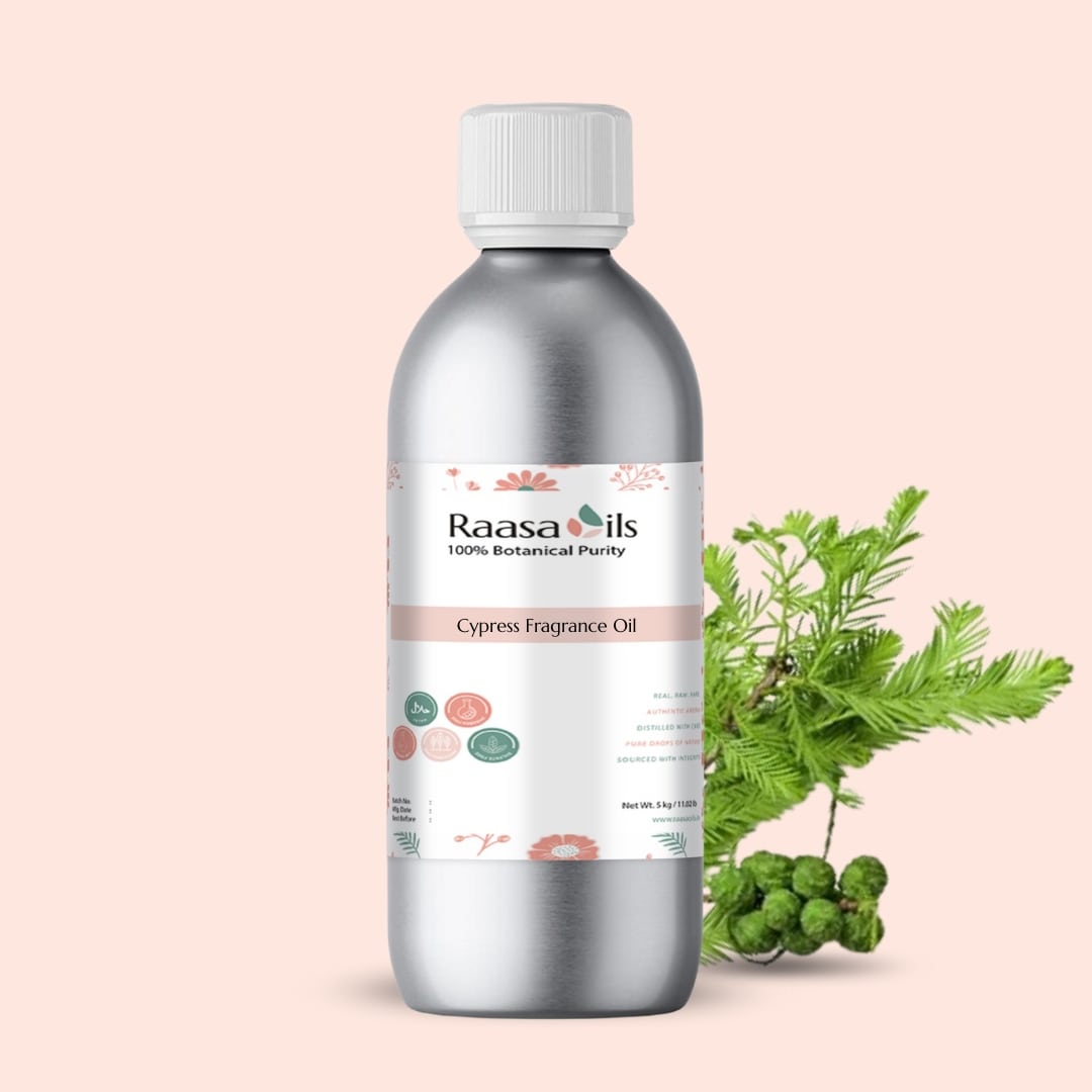 Bottle of Raasa Oils Cypress Fragrance Oil with green leaves on a light pink background