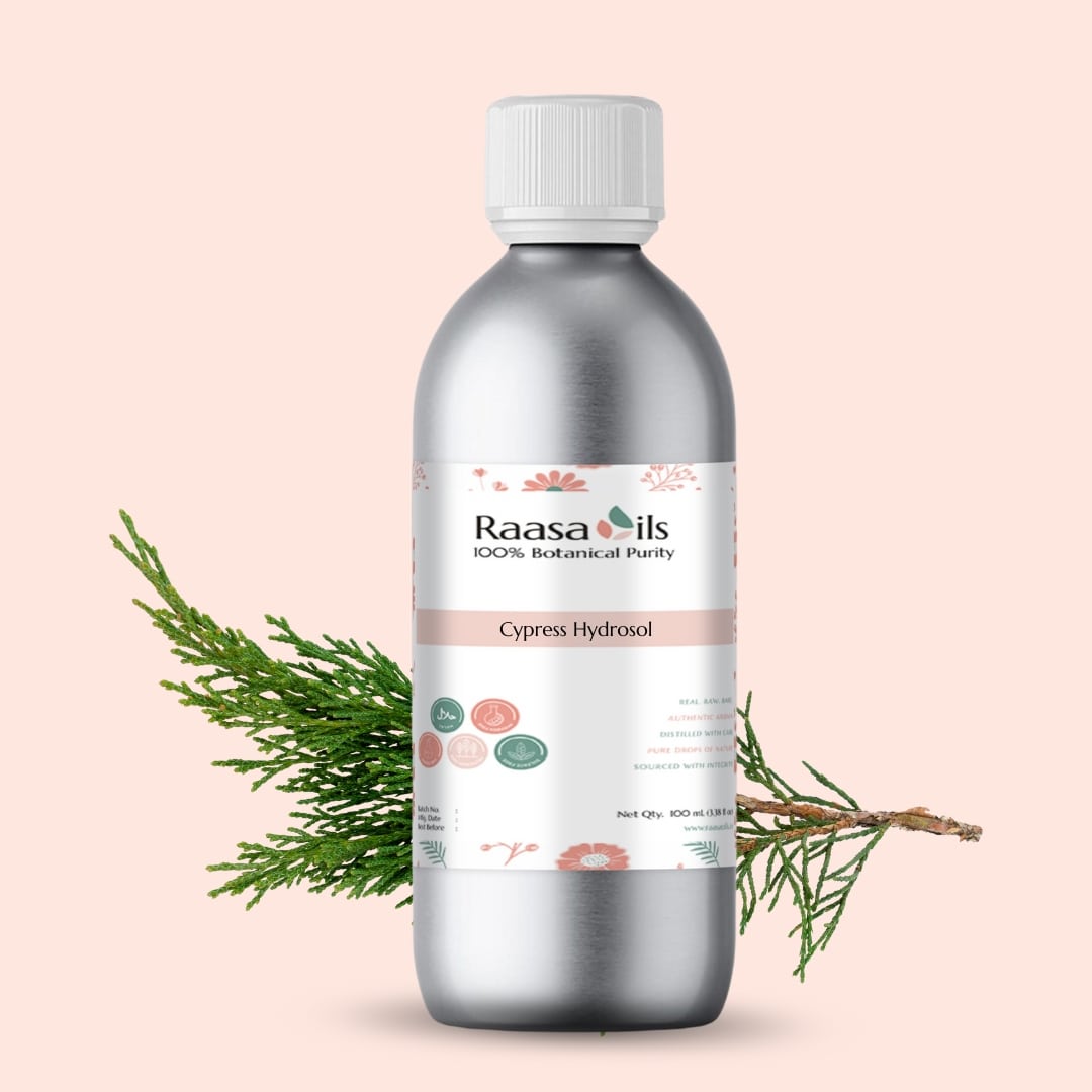 Bottle of Raasa Oils Cypress Hydrosol with a branch on a light pink background