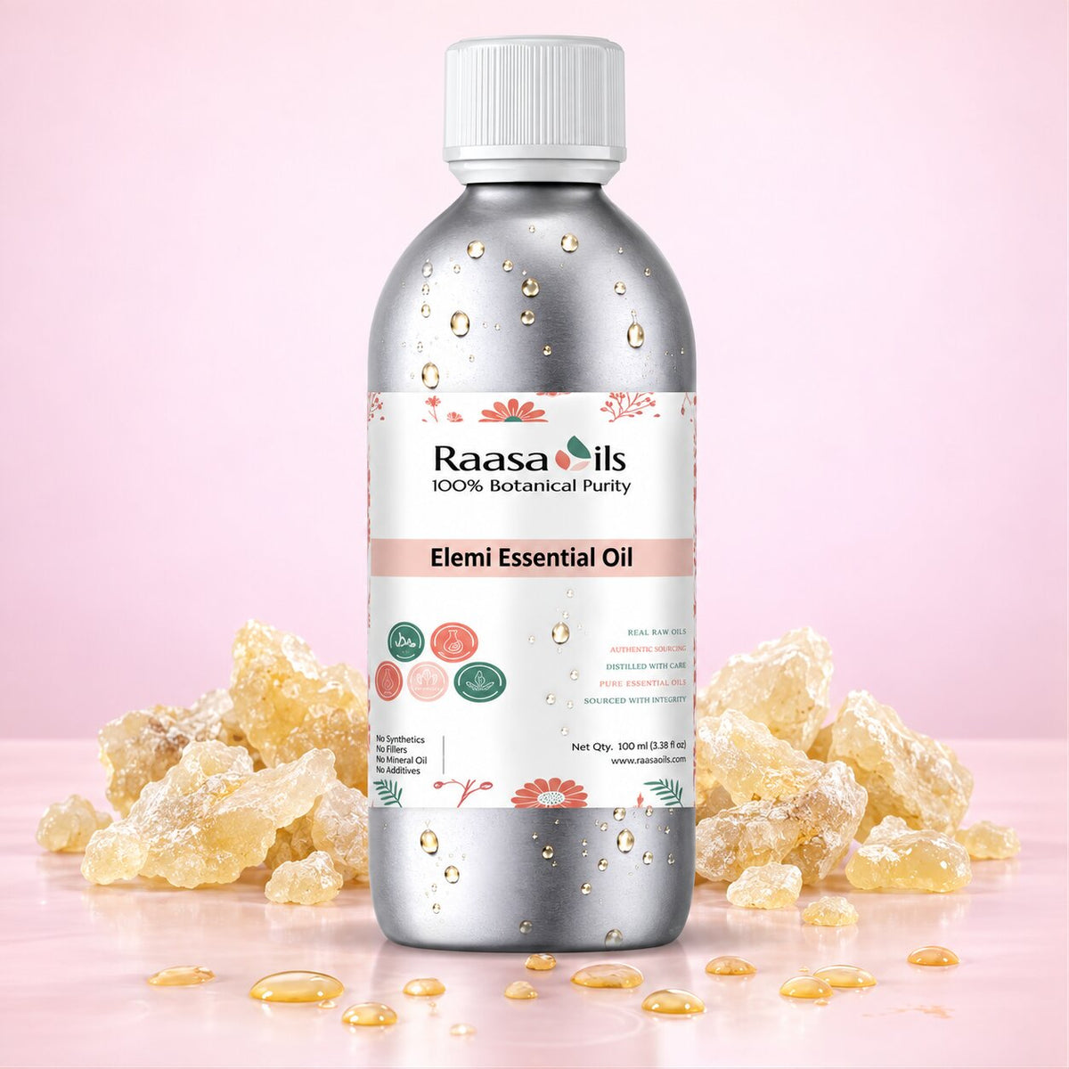 A bottle of Raasa Oils Elemi Essential Oil centered on a soft pink background, surrounded by translucent yellow wax crystals and a few droplets of oil. The bottle is metallic silver with a white cap and a white label featuring floral accents and product text.