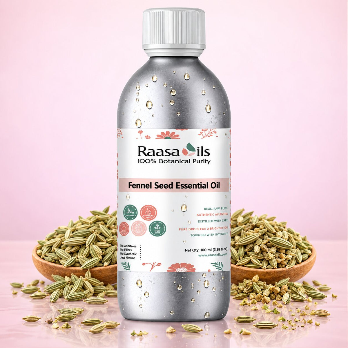 A bottle of Raasa Oils Fennel Seed Essential Oil centered on a pink background, surrounded by bowls of fennel seeds and flowers. The bottle is metallic silver with a white cap and a white label featuring pink and green accents.