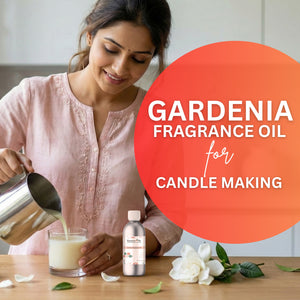 Woman pouring liquid into a glass with a bottle of gardenia fragrance oil and flowers on a table.