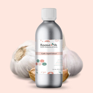 Bottle of Raasa Oils Garlic Liquid Extract with garlic bulbs in the background on a light pink background