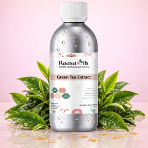 A bottle of Raasails Green Tea Extract centered on a reflective surface with green tea leaves and water droplets around it, against a soft pink background.