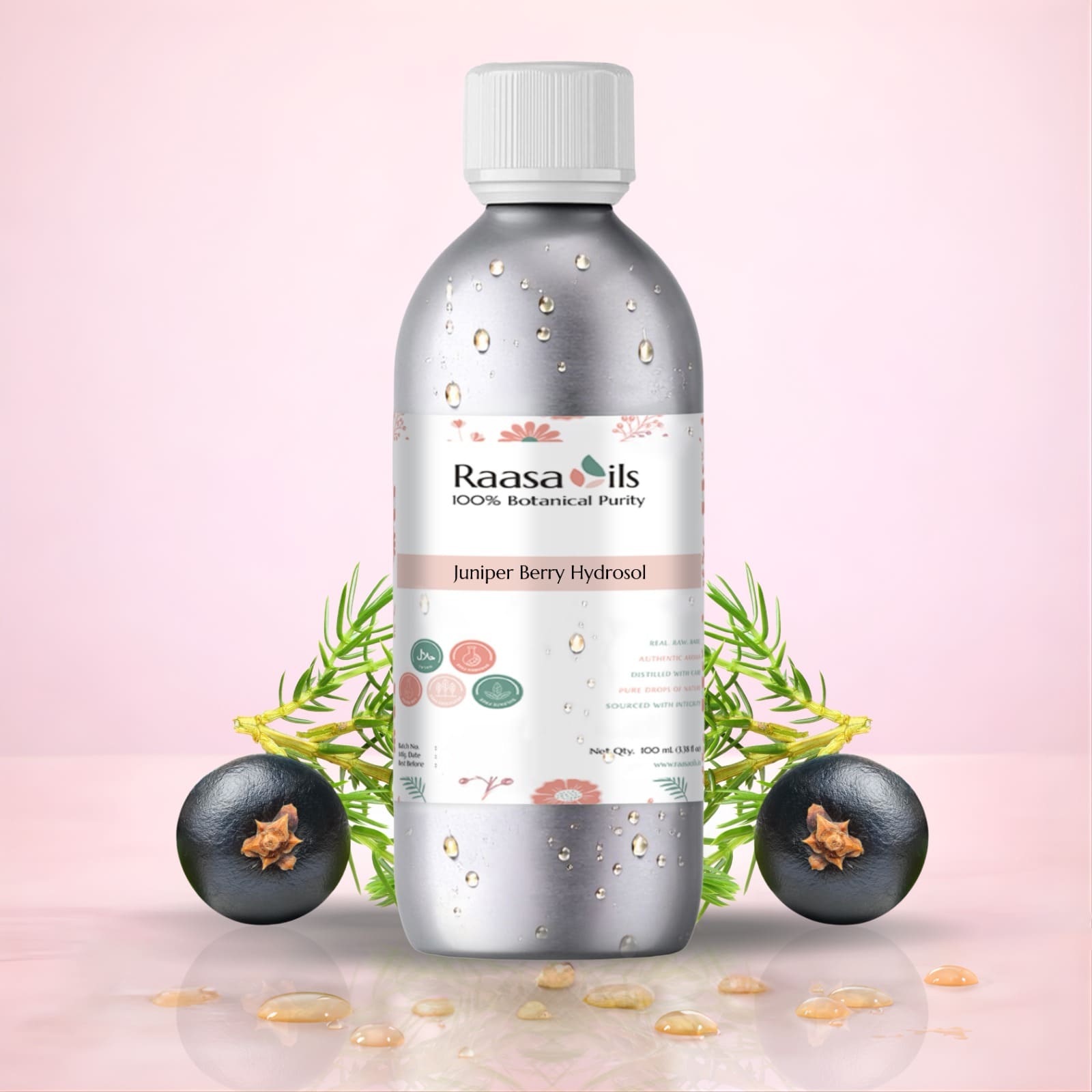 Bottle of Raasa Oils Juniper Berry Hydrosol with juniper berries on a pink background