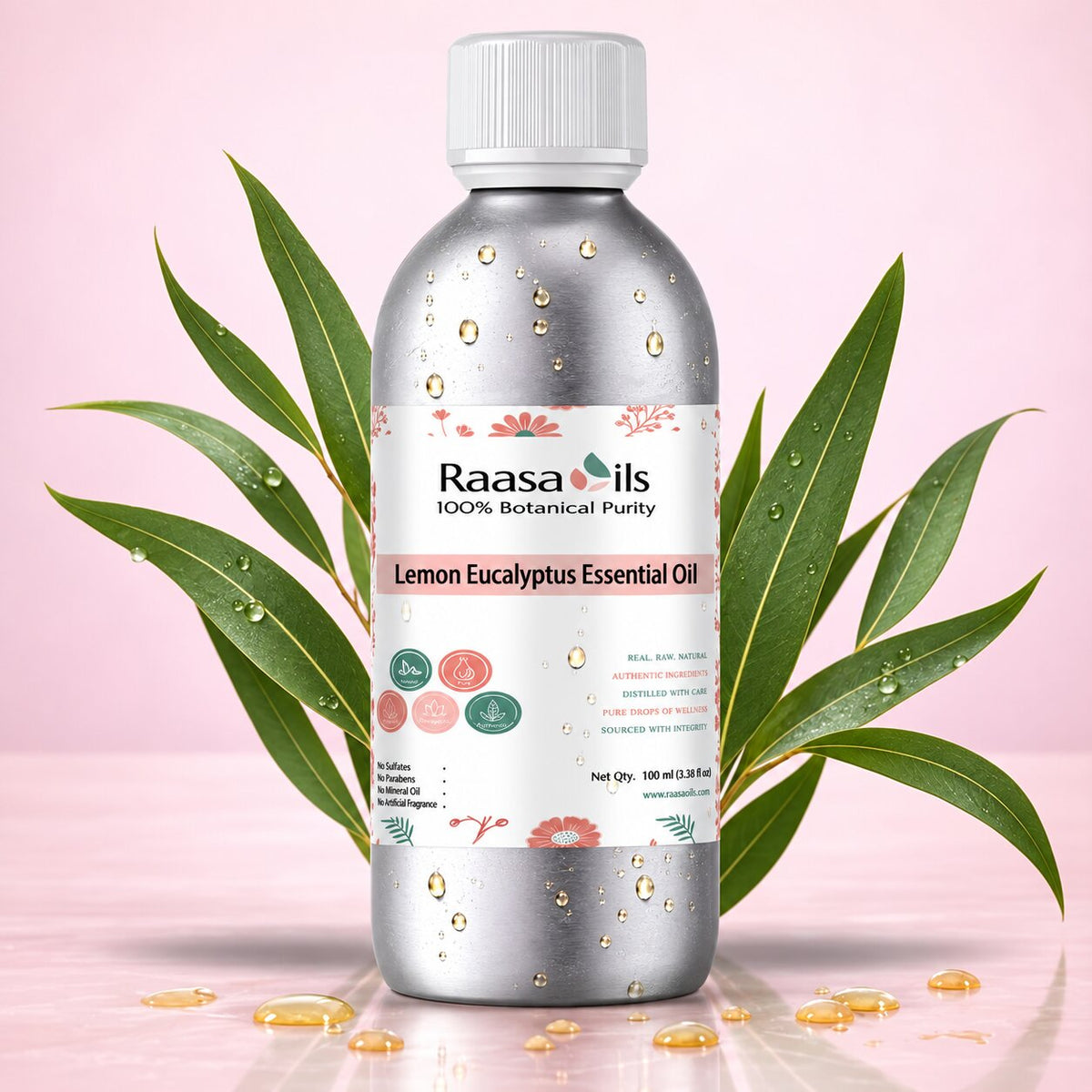 A bottle of Raasa oils Lemon Eucalyptus Essential Oil centered against a soft pink background, flanked by green eucalyptus leaves and small scattered golden oil droplets. The bottle is metallic silver with a white cap and a white label featuring pink floral accents and product text.