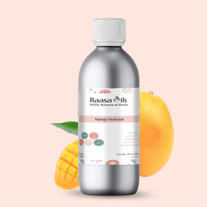 Bottle of Raasa Oils Mango Hydrosol with mangoes on a light pink background