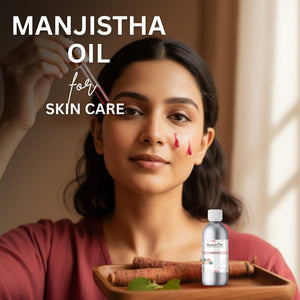 Woman applying manjistha oil to her face with a dropper, next to a bottle of manjistha oil on a tray.