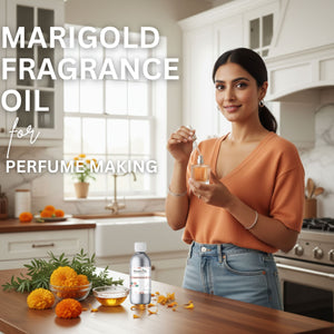Woman holding a bottle of marigold fragrance oil in a kitchen setting with marigold flowers and oil bottles on the counter.
