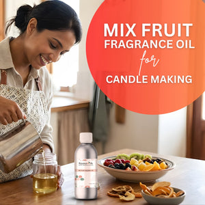 Woman pouring liquid into a jar with a bottle of fruit fragrance oil and a bowl of fruits on a table.