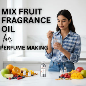 Woman holding a bottle of fruit fragrance oil with various fruits on a table.