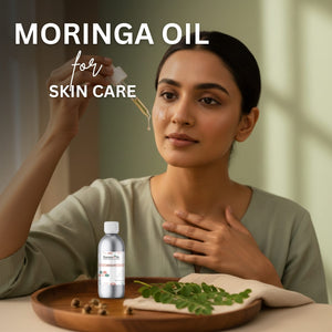 Woman applying Moringa oil for skin care with a bottle and leaves on a tray.