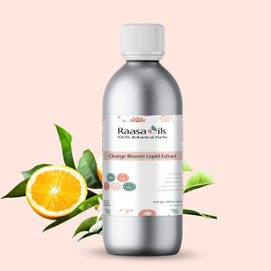 Bottle of Raasa Oils Orange Blossom Liquid Extract with orange and leaves on a light pink background