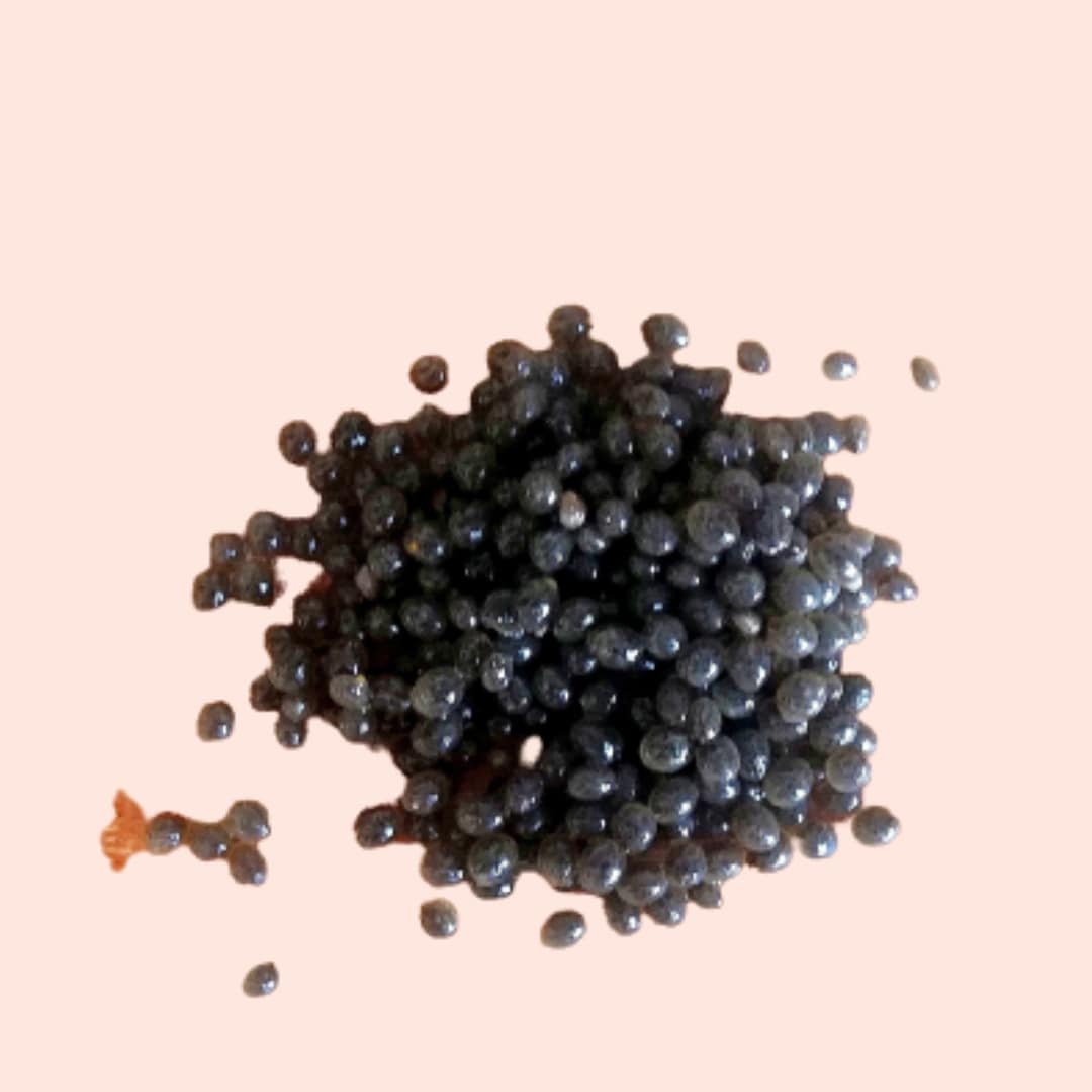 Close-up of black caviar on a light pink background