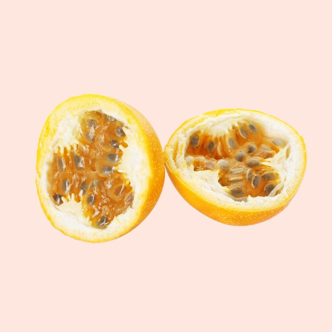 Two halves of a passion fruit on a pink background