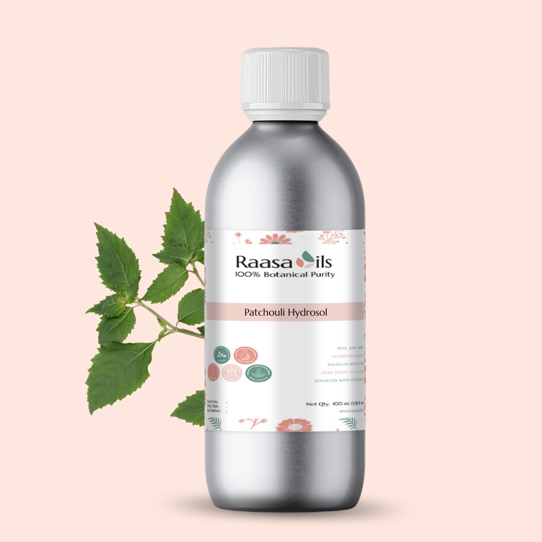 Bottle of Raasa Oils Patchouli Hydrool with a leaf on a light pink background