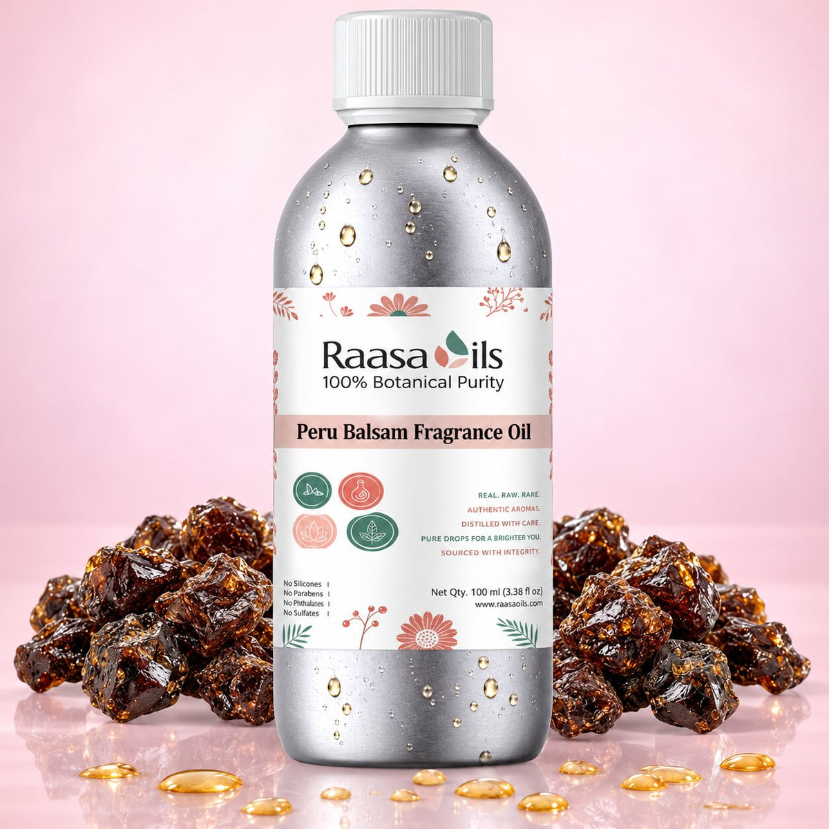 A bottle of Raasa Oils Peru Balsam Fragrance Oil centered against a soft pink background, flanked by clusters of dark brown resin pieces and scattered golden oil droplets. The bottle is metallic silver with a white cap and a white label featuring floral accents and product text.