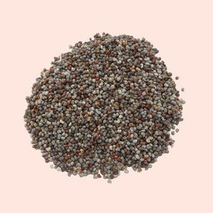 Close-up of a pile of multicolored seeds on a light pink background