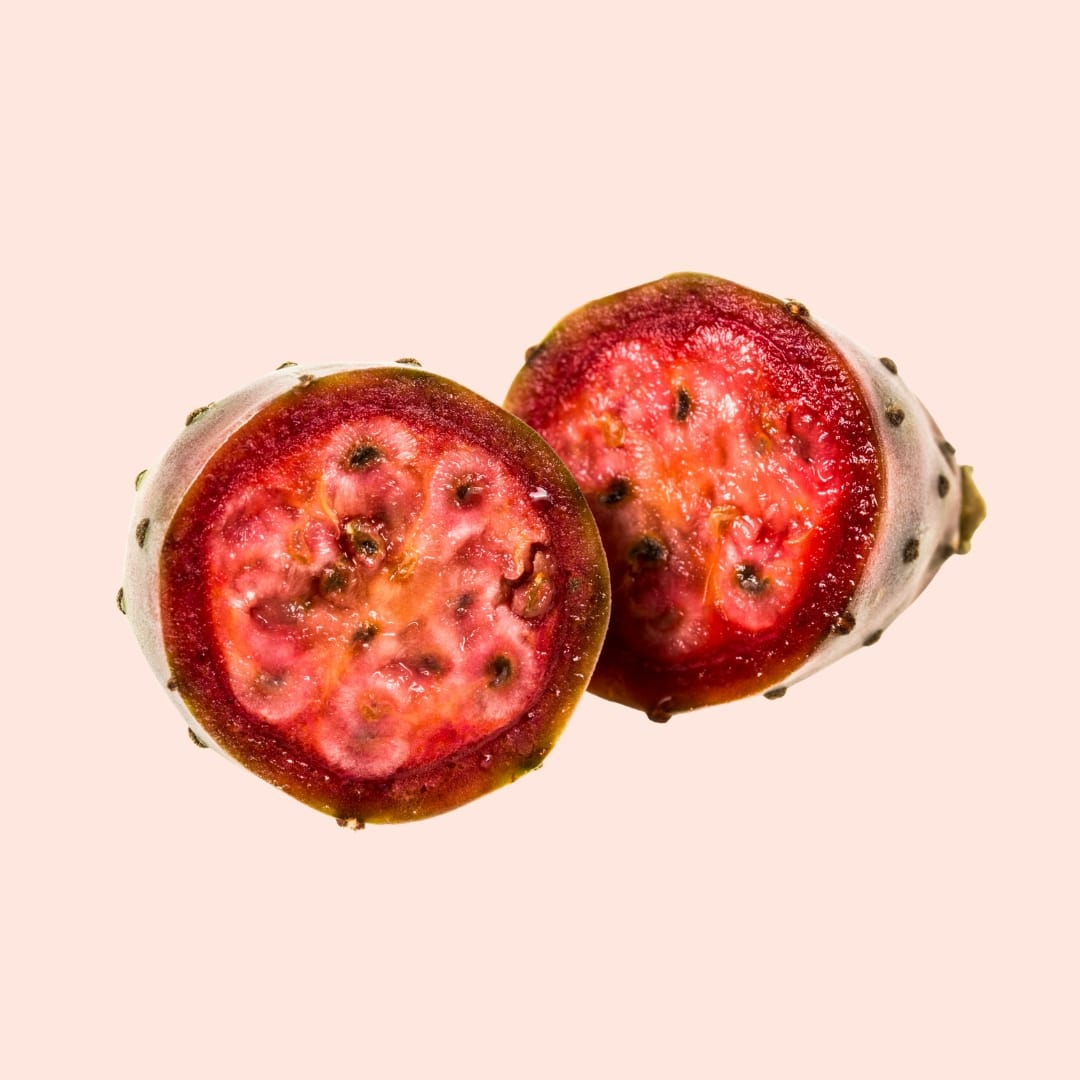 Two halves of a prickly pear cactus fruit on a beige background