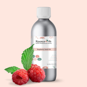 Bottle of Raasa Oils Raspberry Seed Oil with raspberries and leaves on a beige background