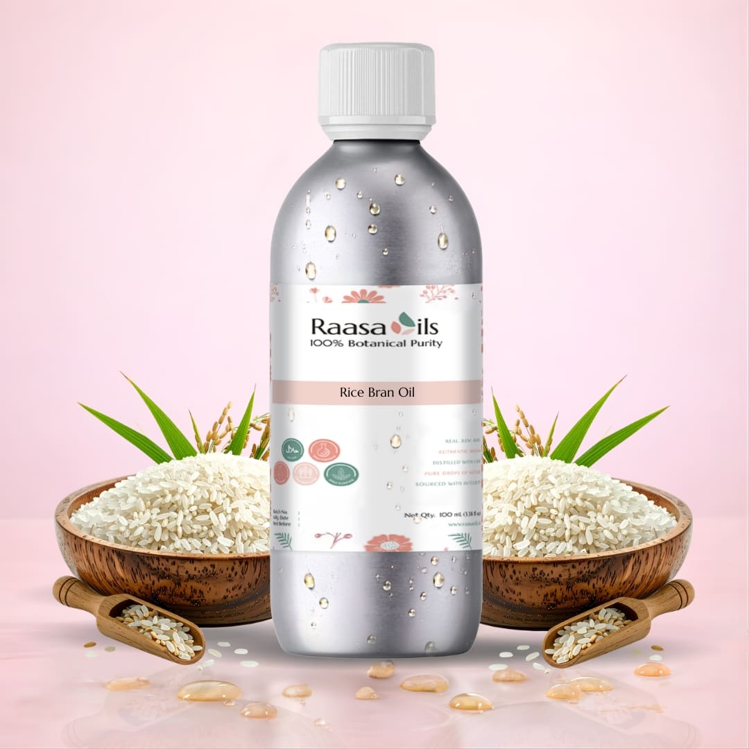 Bottle of Raasa Oils Rice Bran Oil with bowls of rice and green leaves on a pink background