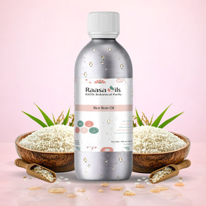 Bottle of Raasa Oils Rice Bran Oil with bowls of rice and green leaves on a pink background