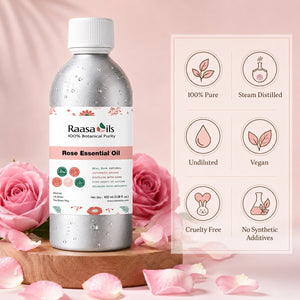 A bottle of Raasa Oils Rose Essential Oil stands on a wooden pedestal surrounded by pink roses and petals, with a pink informational panel showing product benefits on the right.