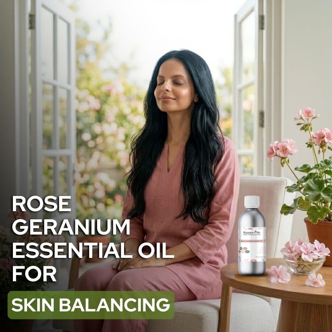 Woman sitting in a room with flowers and a bottle of Rose Geranium essential oil.