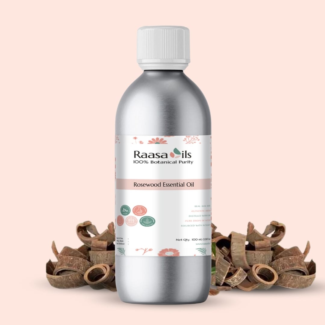 Bottle of Raasa Oils Rosewood Essential Oil on a beige background with rosewood pieces.