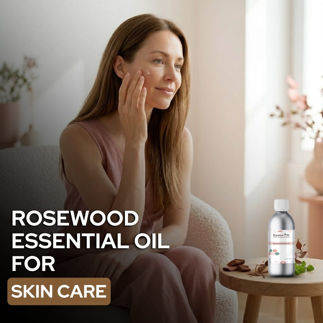 Woman applying rosewood essential oil to her face with a bottle of the product on a table.