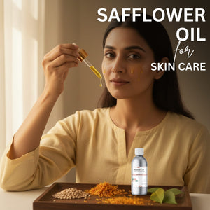 Woman applying safflower oil to her face with a dropper, surrounded by safflower seeds and leaves on a wooden tray.