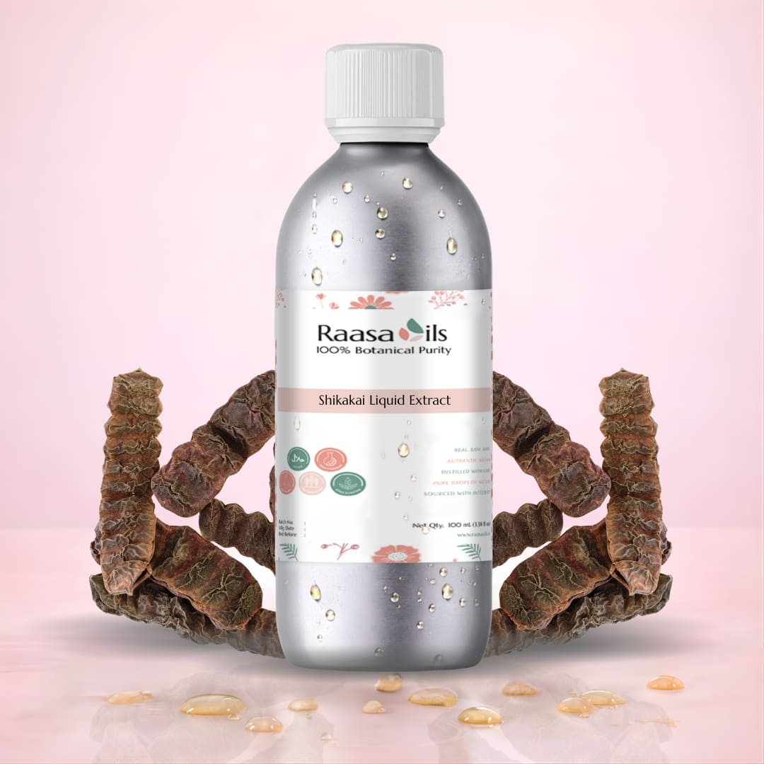 Bottle of Raasa Oils Shikakai Liquid Extract with dried shikakai roots on a pink background