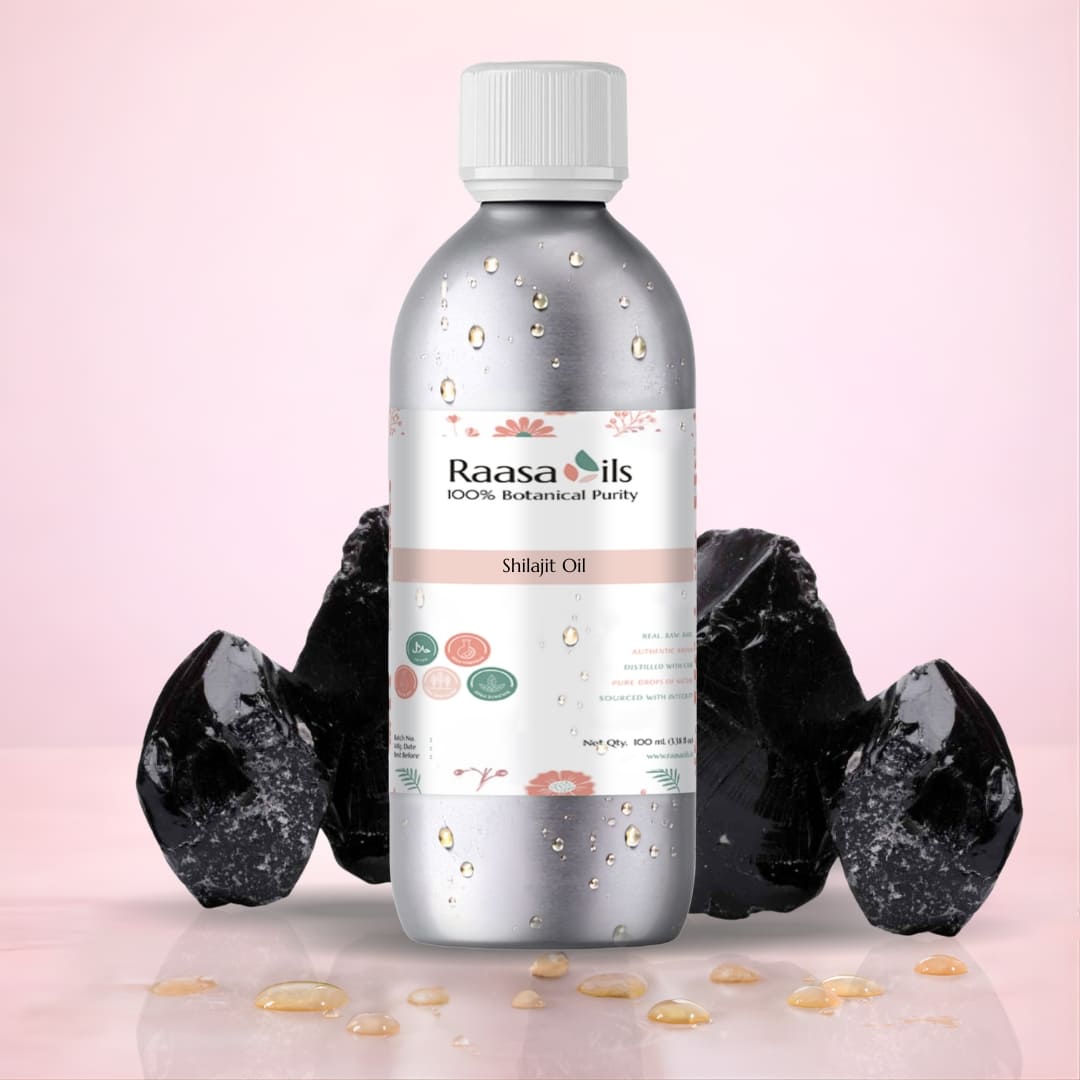 Bottle of Raasa Oils Shilajit Oil with black stones on a pink background