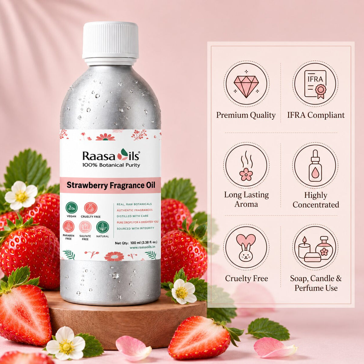 A bottle of Raasa Oils Strawberry Fragrance Oil stands on a wooden block beside a pink informational panel with icons for premium quality, IFRA compliance, long-lasting aroma, high concentration, cruelty free, and soap/candle/perfume use. The bottle is silver with a white cap and a pink-and-white label, surrounded by sliced strawberries, whole strawberries, green leaves, and small white flowers on a soft pink background.
