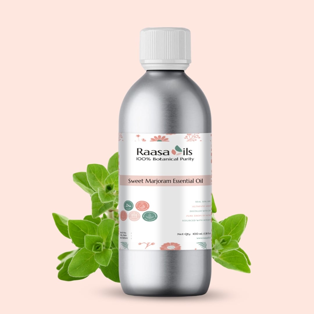 Silver bottle of Raasa Oils Sweet Marjoram Essential Oil with green leaves on a light pink background