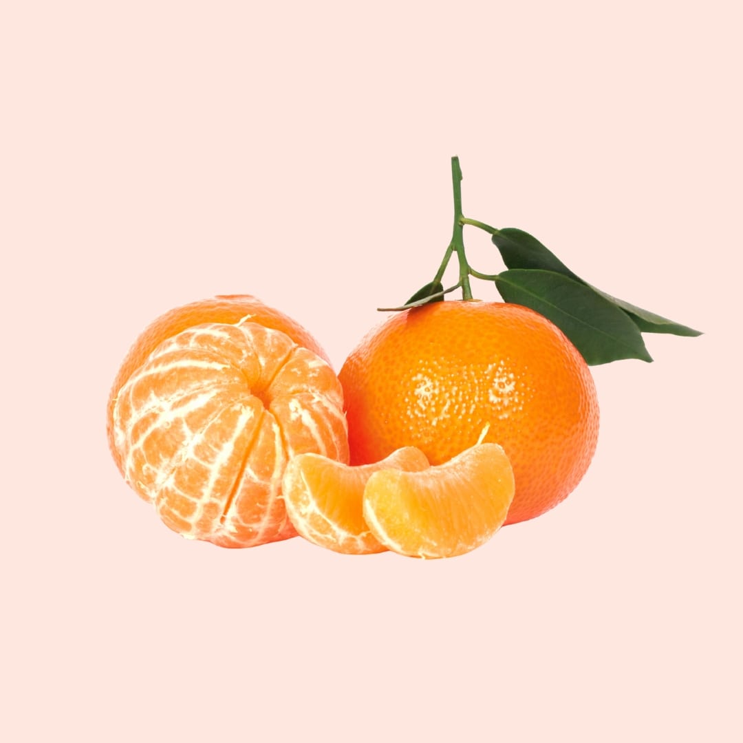 Oranges with a peeled one on a light pink background