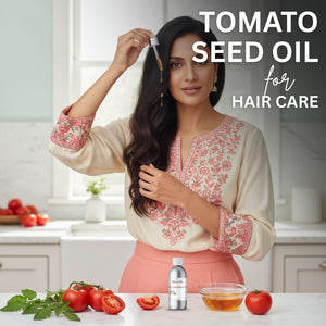 Woman with long hair holding a dropper of tomato seed oil in a kitchen setting with tomatoes and oil on the counter.