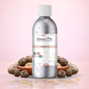 Bottle of Raasa Oils Triphala Oil with Triphala fruits on a pink background