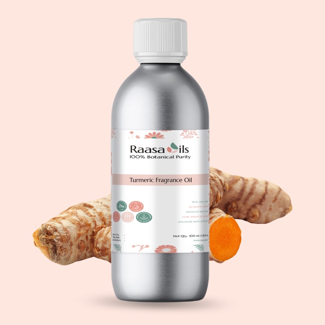 Bottle of Raasa Oils Turmeric Fragrance Oil with turmeric root and turmeric root piece on a beige background
