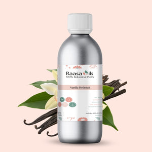 Bottle of Raasa Oils Vanilla Hydrosol with vanilla beans and flowers on a light pink background