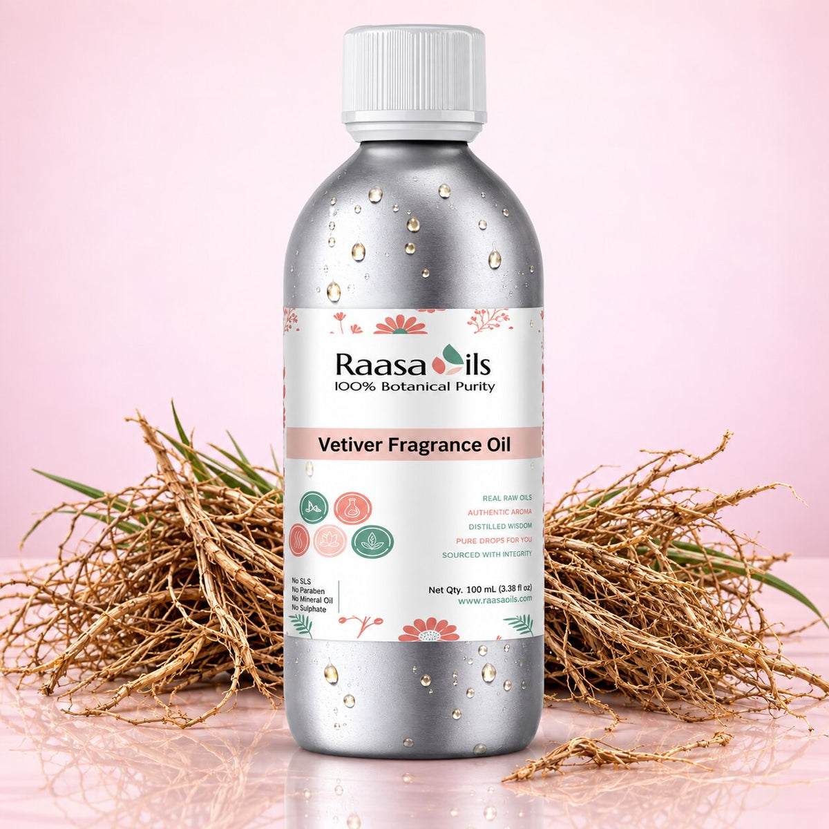 A bottle of Raasa oils Vetiver Fragrance Oil, 100 mL, with a silver metallic finish, white cap, and a white label with botanical illustrations, set against a pink background with dried vetiver grass props.