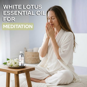 Woman meditating with a bottle of White Lotus essential oil on a table.