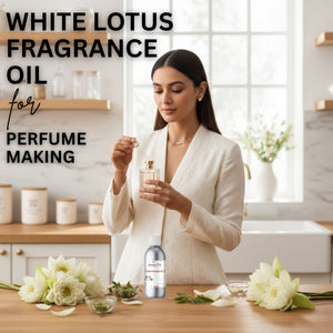 Woman holding a bottle of White Lotus fragrance oil in a kitchen setting with flowers and containers.